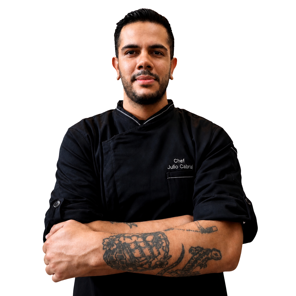Julio Cabral usando uniforme preto de chef, com os braços cruzados.