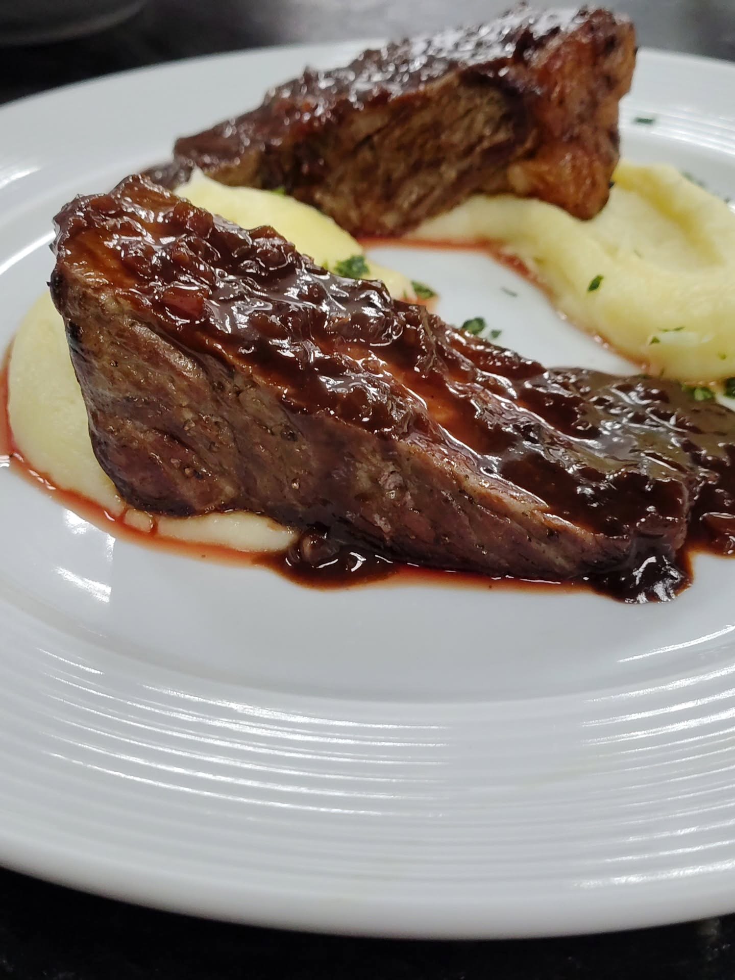 Prato com carne, molho e acompanhamento.